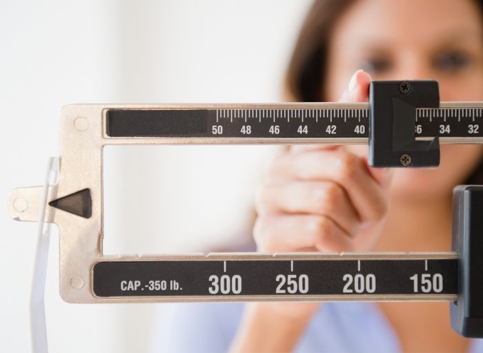 woman adjusting scale